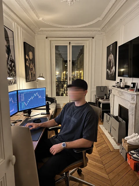 Nick at his desk with trading charts on the monitors.